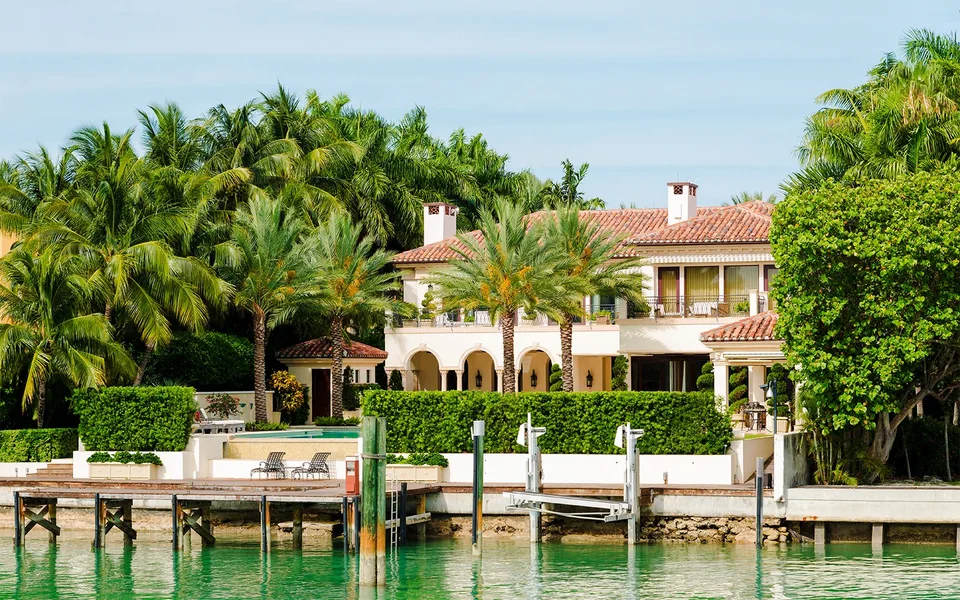Waterfront home with a private dock and palm trees on Biscayne Bay