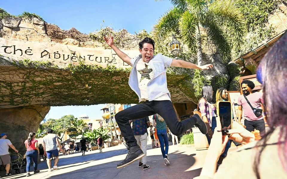Visitor jumping outside the Islands of Adventure entrance at Universal Orlando