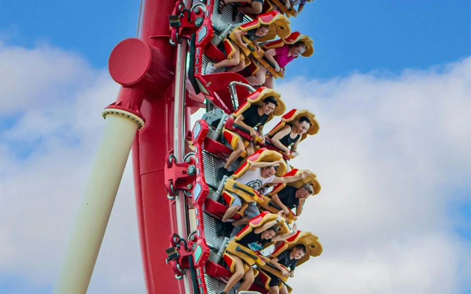 Riders on a red outdoor roller coaster at Universal Orlando
