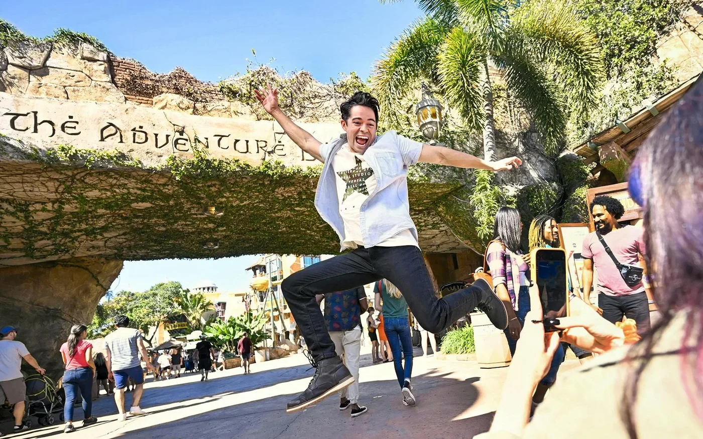 Visitor jumping outside the Islands of Adventure entrance at Universal Orlando
